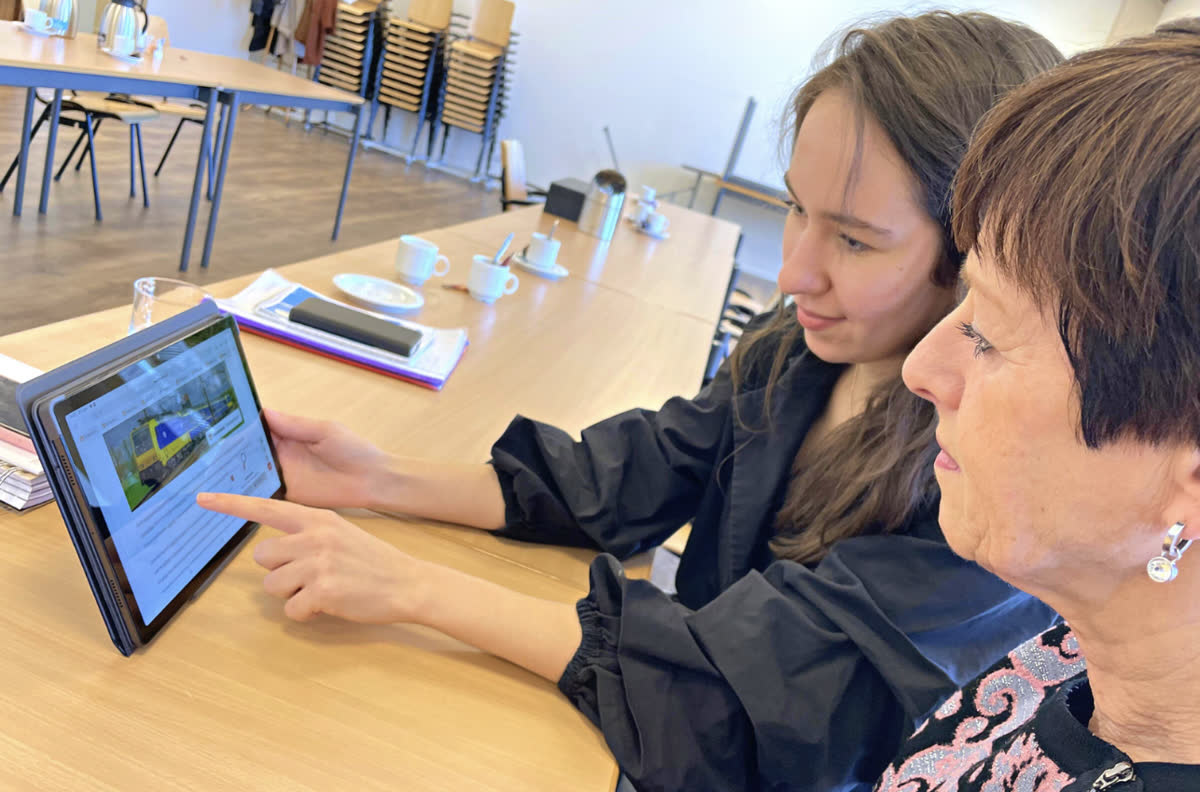 Twee panel-leden lezen samen een tekst op een tablet en geven feedback